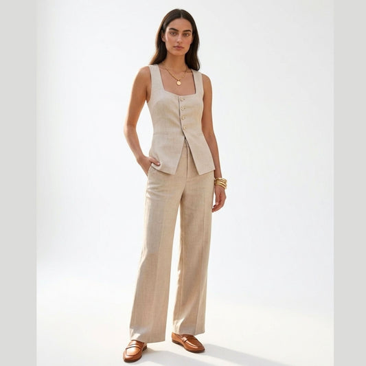 Woman wearing a beige sleeveless top and wide-leg pants on a white background