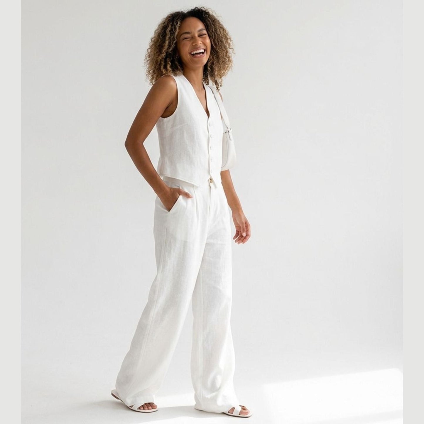 Woman wearing a white jumpsuit on a plain background