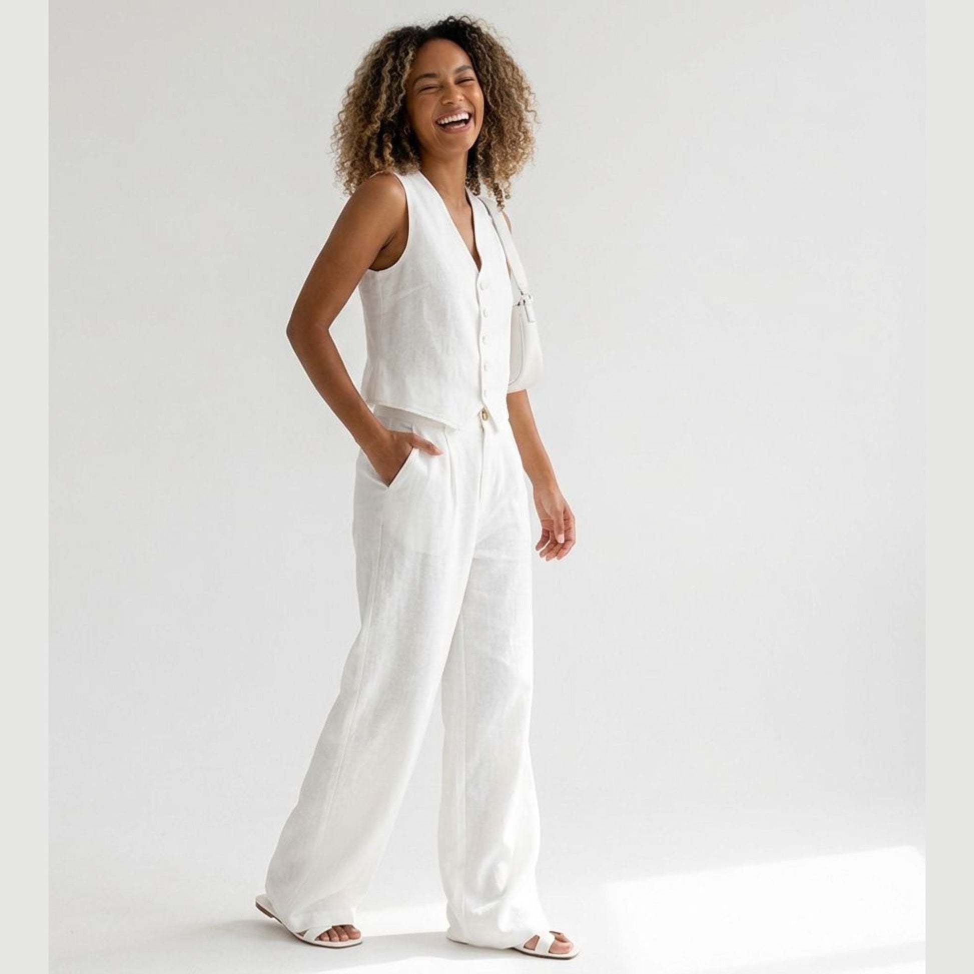 Woman wearing a white jumpsuit on a plain background